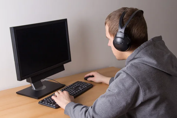 Genç bilgisayar ve kulaklık ile — Stok fotoğraf