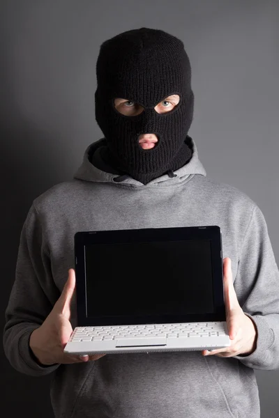 Masked man with computer over grey — Stock Photo, Image