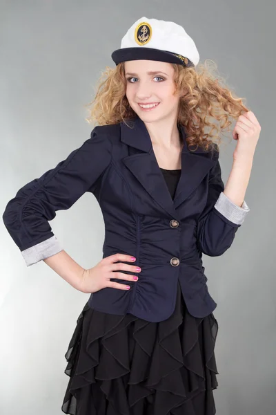 Young beautiful woman in captain cap over grey — Stock Photo, Image