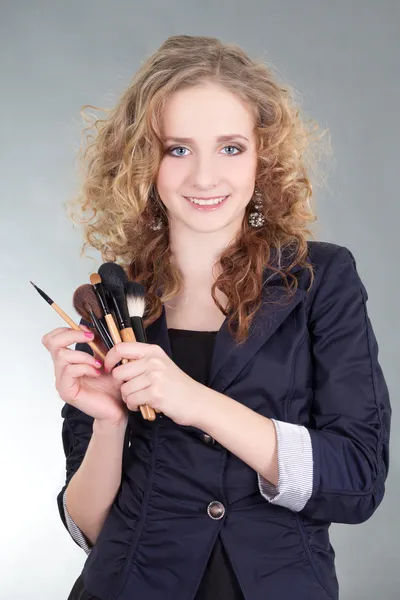 Jonge mooie vrouw met make-up borstels — Stockfoto