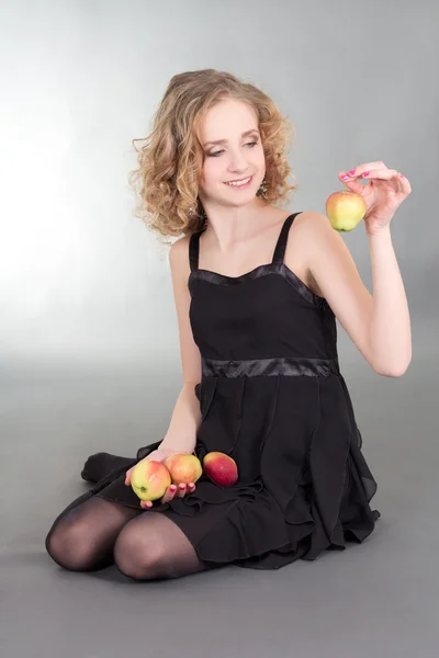 Mladá blondýna sedí s jablky — Stock fotografie
