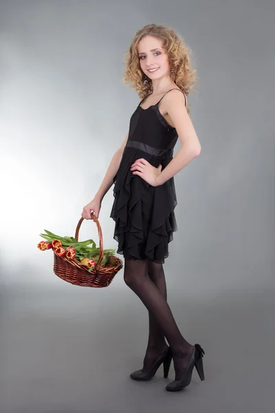 Young woman posing with basket of flowers – stockfoto