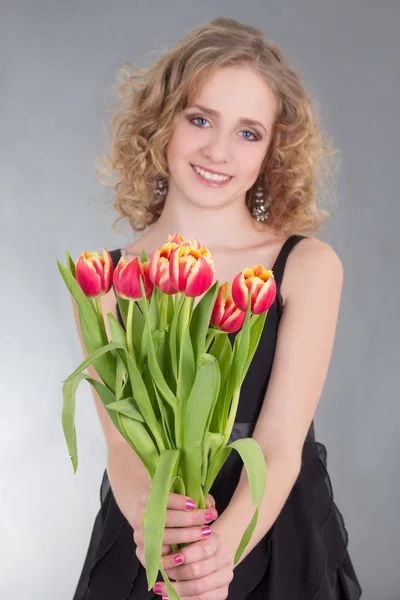 Mladá žena dává Tulipán květy — Stock fotografie
