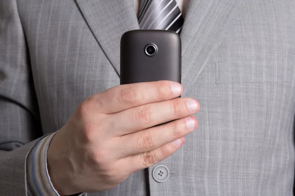 Affärsman hand med mobiltelefon — Stockfoto