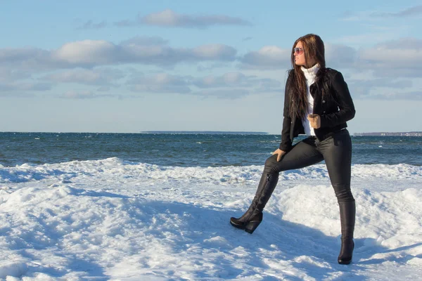 Retrato de joven morena en la playa de invierno — Foto de Stock