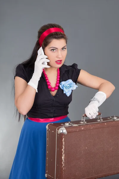 Pinup woman with retro suitcase and phone — Stock Photo, Image