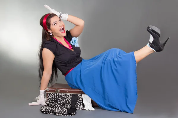 Funny pinup girl sitting on overfilled suitcase — Stock Photo, Image