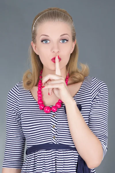 Attraente ragazza pinup in abito a righe con un dito sulle labbra — Foto Stock