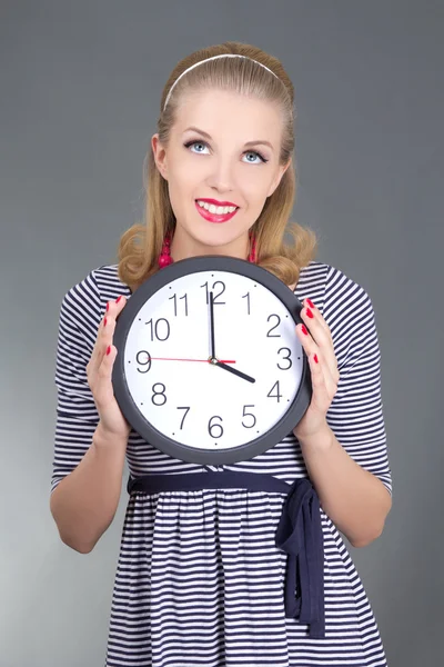 Dreaming pinup girl in striped dress with clock — Stock Photo, Image
