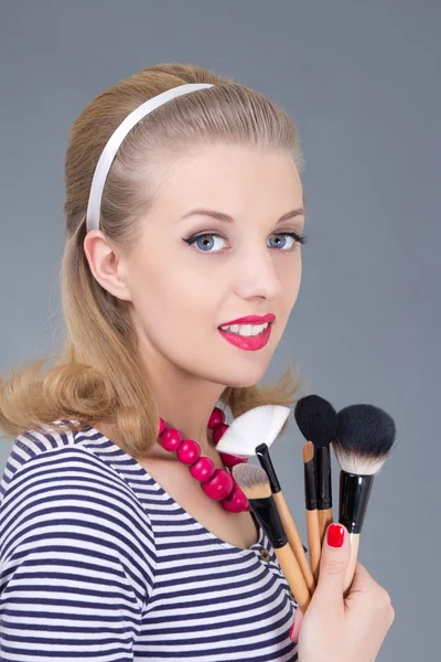 Pinup meisje met make-up borstels — Stockfoto