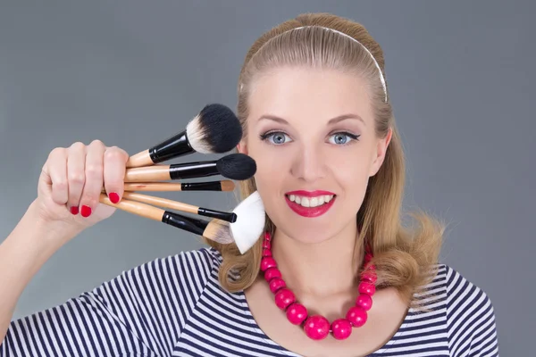 Pinup woman with make up brushes — Stock Photo, Image