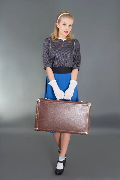 Young beautiful pinup girl with retro suitcase over grey — Stock Photo, Image