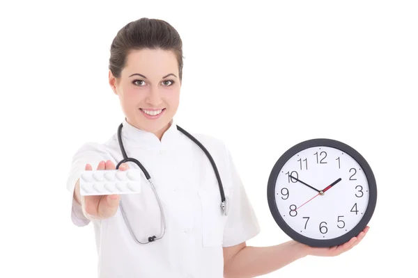 Jeune femme médecin avec pilules et horloge sur blanc — Photo