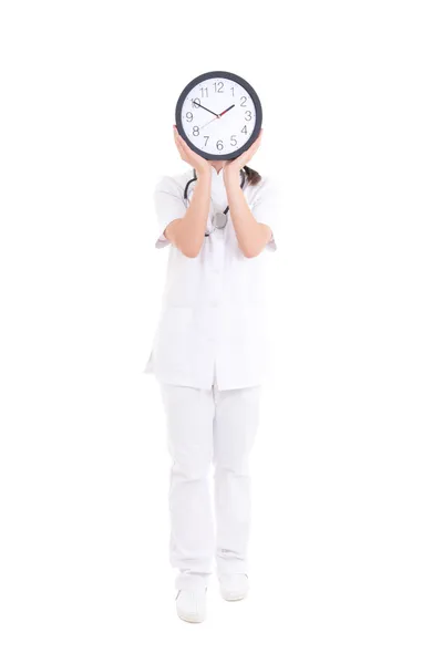 Young female doctor with clock covering face over white — Stock Photo, Image