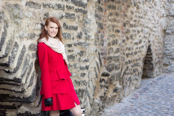 Attractive woman standing over old brick wall — Stock Photo, Image