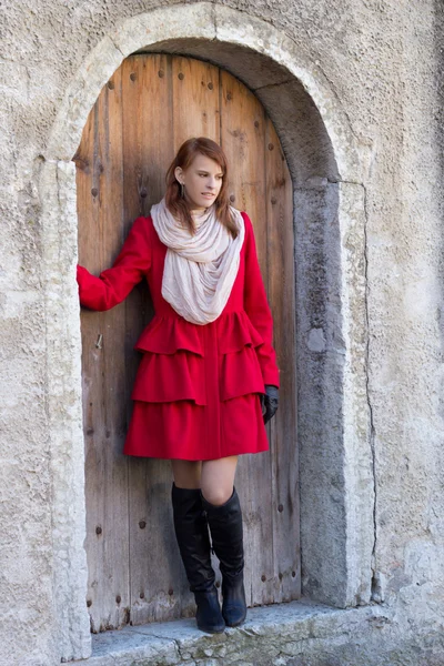 Mladé krásné redhaired žena pózuje před staré dveře — Stock fotografie