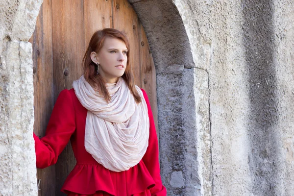 Rödhårig kvinna poserar framför den gamla dörren — Stockfoto