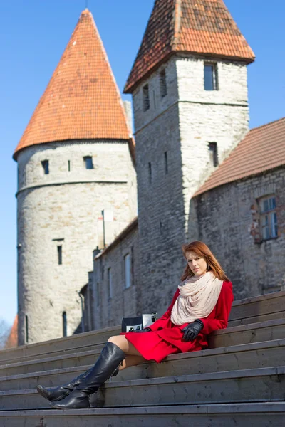Mladá žena sedí na schodech ve starém městě — Stock fotografie