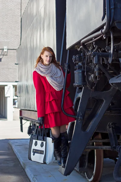 Mujer en tren vintage y capa roja — Foto de Stock