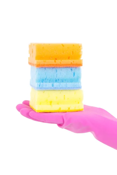 Female hand in rubber glove with colorful sponges over white — Stok Foto