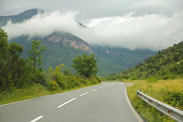 Straße zu Bergen und schönen Wolken — Stockfoto