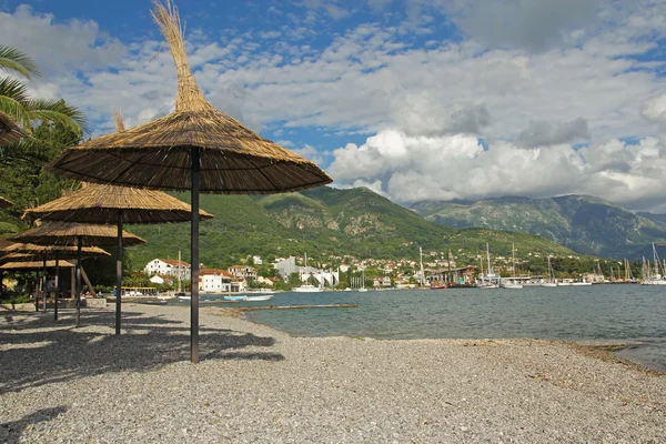 Halm parasollerna på stranden i tivat — Stockfoto