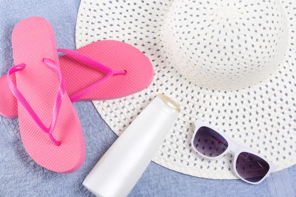 Mavi havlu üzerinde flip flop, şapka, güneş gözlüğü — Stok fotoğraf
