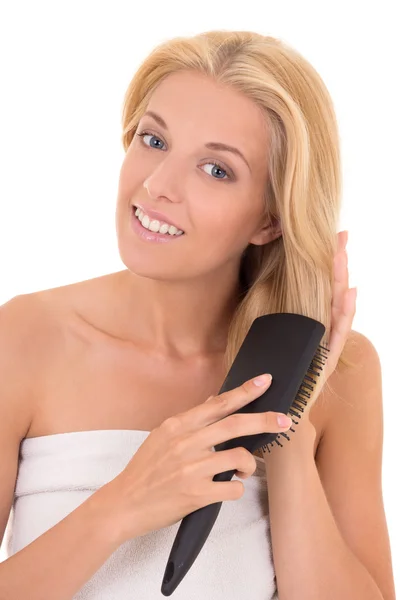 Приваблива жінка чистить волосся на білому тлі — стокове фото