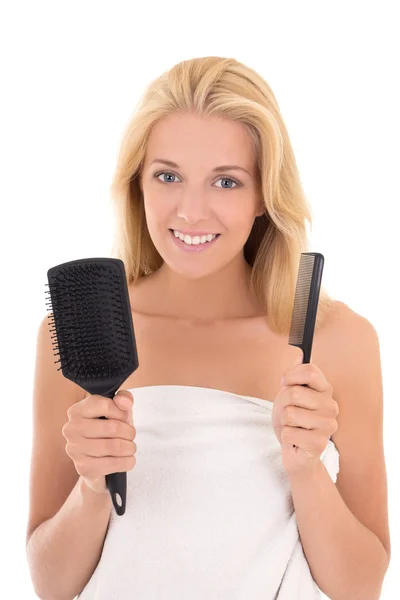 Jovem mulher atraente com escovas de cabelo no fundo branco — Fotografia de Stock