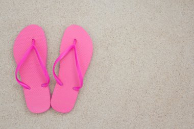 tropikal plaj beyaz kum üzerine kırmızı flip flop