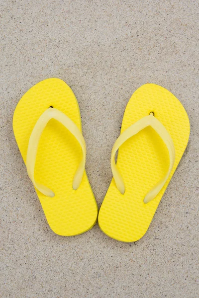 Gelbe Flip-Flops auf dem Sand von einem tropischen Strand — Stockfoto