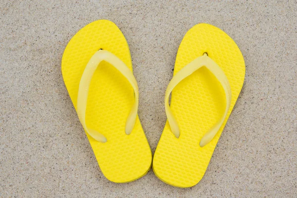 Gelbe Flip Flops im Sand — Stockfoto