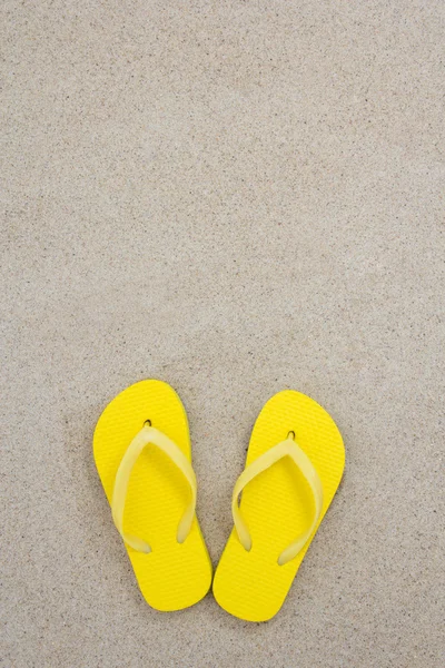 Infradito giallo sulla sabbia bianca della spiaggia — Foto Stock