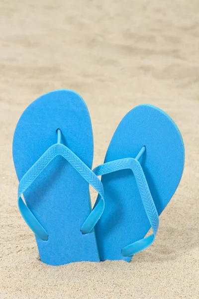 Parlak mavi kauçuk flip flop'lar kum üzerinde — Stok fotoğraf