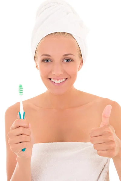 Ελκυστική γυναίκα με οδοντόβουρτσα και πετσέτα μπράβο πάνω από λευκό — Φωτογραφία Αρχείου
