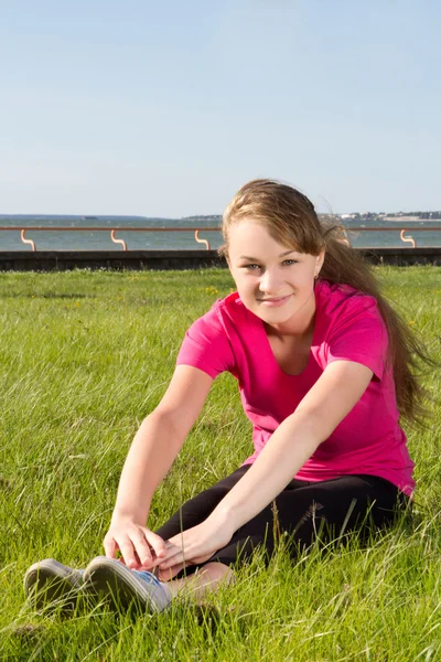 Young happy girl stretching in park — Stock Photo, Image
