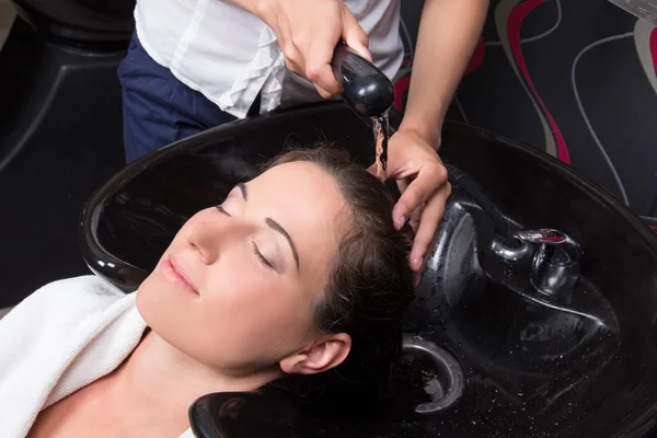 Mulher bonita recebendo uma lavagem de cabelo no salão de beleza — Fotografia de Stock