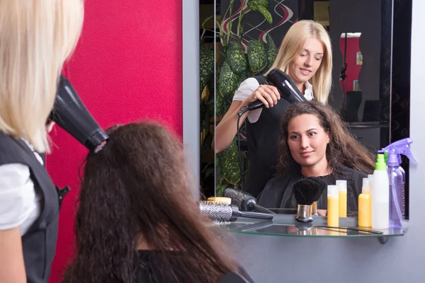 Hairstylist drying woman's hair in beauty salon — Stock Photo, Image