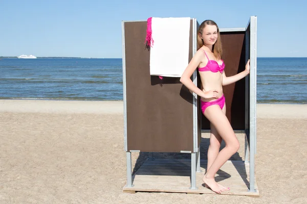 Mujer delgada hermosa en cambio cabaña en la playa — Foto de Stock