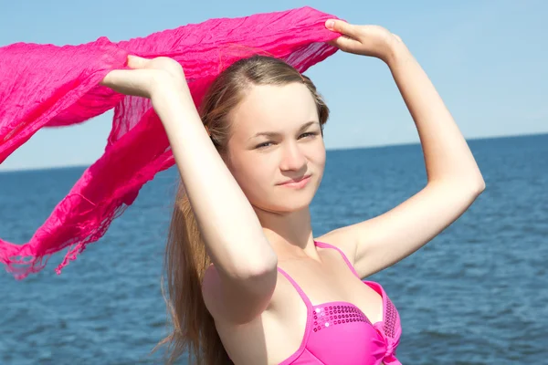 Portrait of beautiful woman in pink swimsuit with scarf on the b — Stock Photo, Image