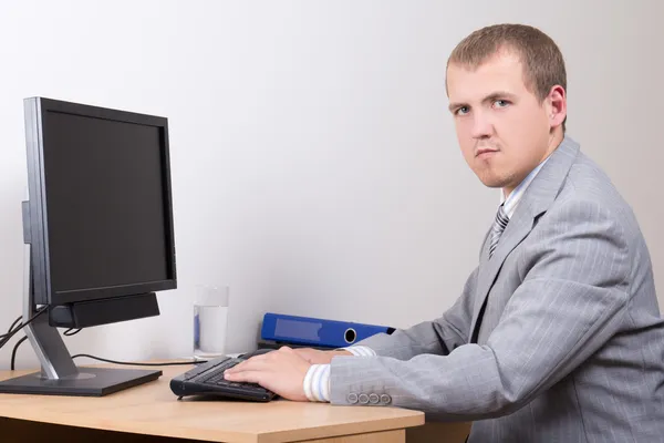 Mladý obchodní muž sedí v kanceláři — Stock fotografie