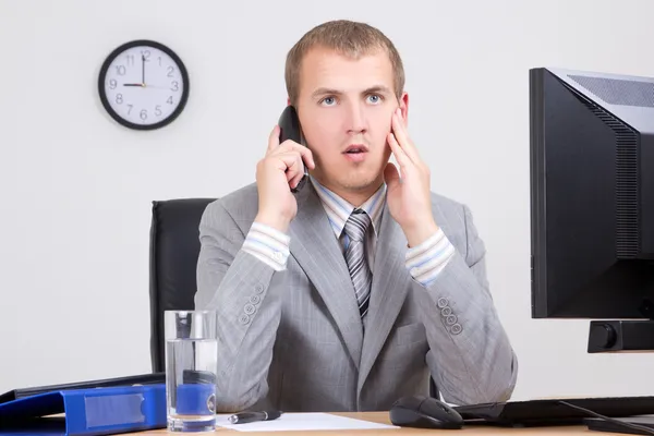 Frightened businessman talking on phone in office — Stock Photo, Image