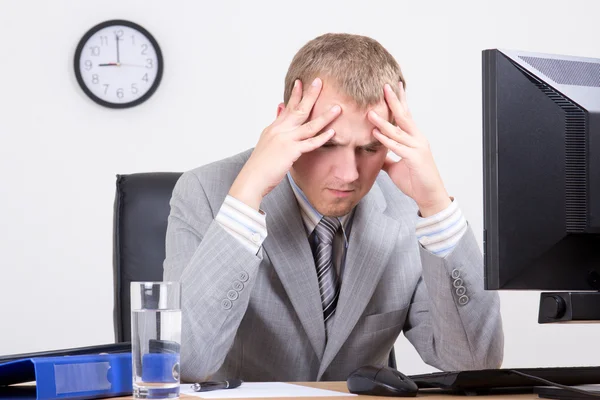 Junger müder Geschäftsmann sitzt im Büro — Stockfoto