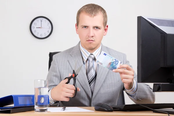 Young business man cutting euro banknote — Stock Photo, Image