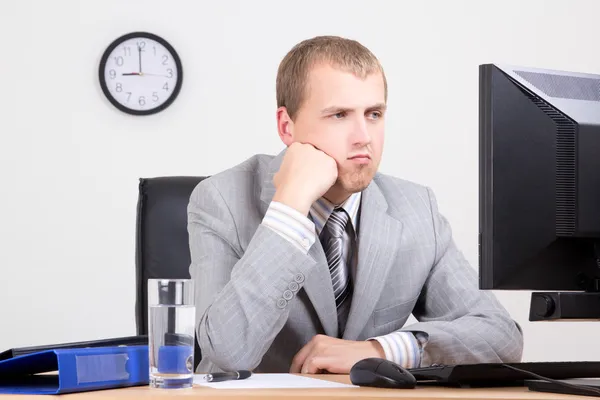 Ung uttråkad affärsman sitter i office — Stockfoto