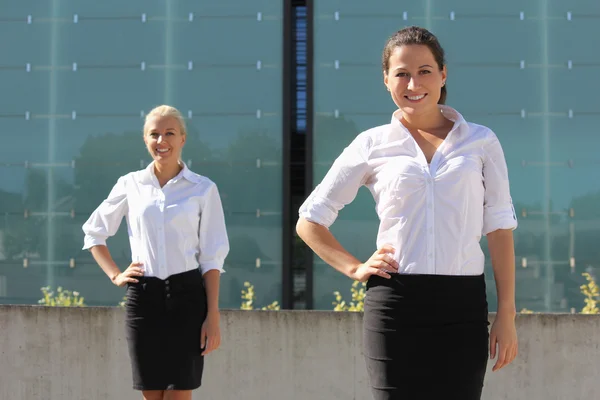 Duas mulheres de negócios atractivos posando na rua — Fotografia de Stock
