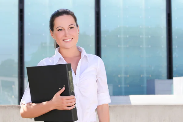 Attractive business woman with folder in the street — Stock Photo, Image