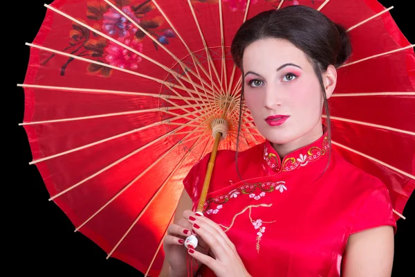 Portrait schöne Geisha in roten japanischen Kleid mit Regenschirm — Stockfoto