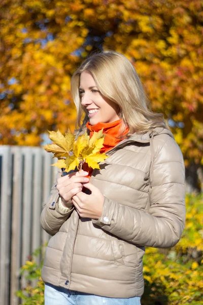 Portrait of young woman with bouquet of maple leaves — Stock Photo, Image