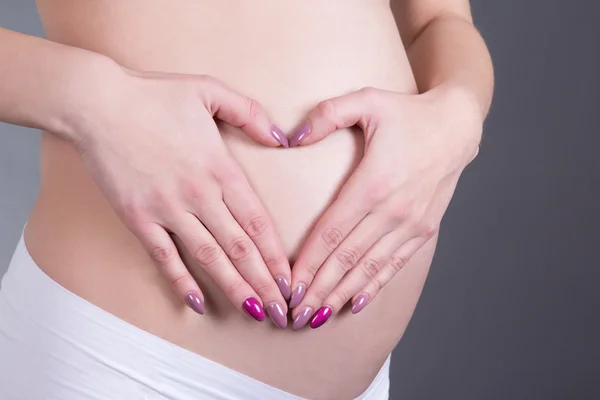 Schwangere mit herzförmigen Händen — Stockfoto